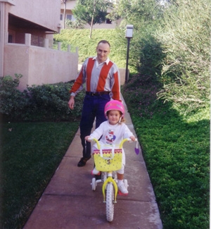 Stu teaching Caitlin how to ride her bike (Personal album)