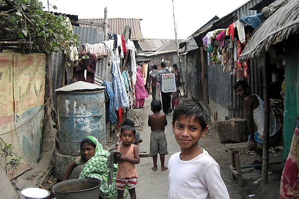 Residents of the Vasantek slum near Dhaka, Bangladesh, put food waste into large metal barrels.