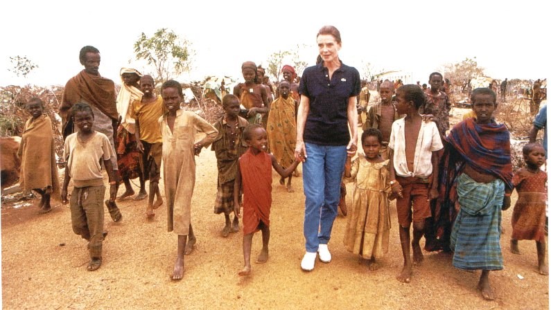 Hepburn in Somalia walking with children represen (http://audreyhepburn.50megs.com/images/unicef9.jpg)