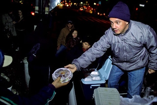 Jorge Muñoz handing out food at "his corner" (NY Daily News)
