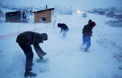 Campers shovel out an exit ramp at the Oceti Sakowin camp where people have gathered to protest the Dakota Access oil pipeline in Cannon Ball, N.D., Tuesday, Dec. 6, 2016. Many Dakota Access oil pipeline opponents who've gathered for months in the camp are committed to staying despite wintry weather and demands that they leave. An overnight storm brought several inches of snow, winds gusting to 50 mph and temperatures that felt as cold as 10 degrees below zero. (AP Photo/David Goldman)