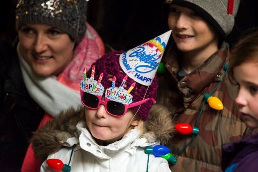 Stella Luken, 5 of Dublin, Ohio, wears a birthday hat and a pair of birthday sun glasses as she waits in line to see Colo, the nation's oldest living gorilla, during Colo's 60th birthday party at the Columbus Zoo and Aquarium, Thursday, Dec. 22, 2016 in Columbus, Ohio. Colo was the first gorilla in the world born in a zoo and has surpassed the usual life expectancy of captive gorillas by two decades. Her longevity is putting a spotlight on the medical care, nutrition and up-to-date therapeutic techniques that are helping lengthen zoo animals' lives. (AP Photo/Ty Wright)