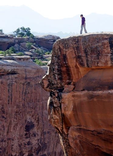 This July 14, 2016, file photo, U.S. Interior Secretary Sally Jewell looks in to a canyon at Gemini Bridges near Moab, Utah, during a tour to meet with proponents and opponents to the 