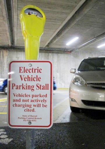 An electric vehicle charging station awaits a vehicle in the parking lot at the Hawaii State Legislature on Wednesday, Jan. 18, 2017 in Honolulu. Renewable energy advocates in Hawaii are pushing a bill to urge the transportation sector to get all its energy from renewable sources in 2045. (AP Photo/Cathy Bussewitz)