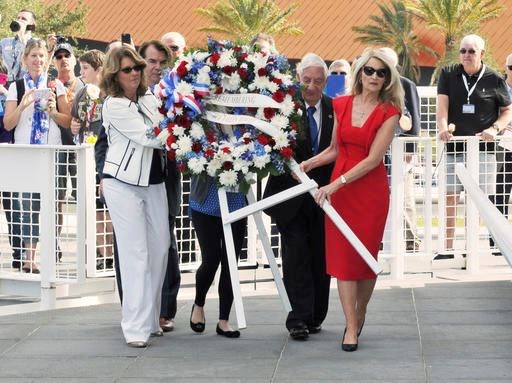 From left, Sheryl Chaffee, daughter of Roger Chaffee; Thad Altman, president of the Astronauts Memorial Foundation; Lowell Grissom, brother of Virgil Grissom; and Bonnie Baer, daughter of Ed White, carry a wreath to the base of the Space Mirror Memorial at the Kennedy Space Center Visitor Complex in Florida on Thursday, Jan. 26, 2017. Moonwalkers and dozens of others who took part in NASA’s Apollo program paid tribute to the three astronauts killed in a fire 50 years ago. (Tim Shortt /Florida Today via AP)