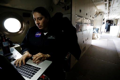 In this Feb. 17, 2017 photo, NASA's lead aircraft integration engineer Eugenia De Marco works inside the Navy P-3 Orion aircraft used for a NASA-led experiment called SnowEx, at Peterson Air Force Base in Colorado Springs, Colo. Instrument-laden aircraft are surveying the Colorado high country this month as scientists search for better ways to measure how much water is locked up in the world's mountain snows - water that sustains a substantial share of the global population. (AP Photo/Brennan Linsley)