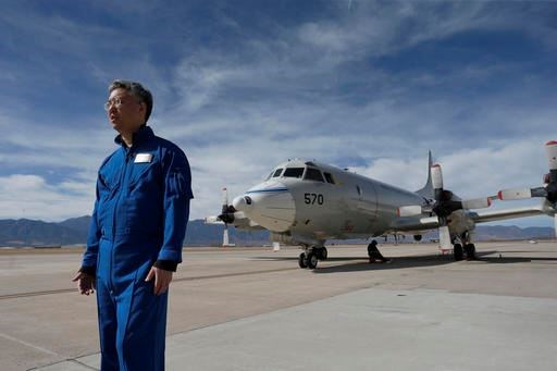 n this Feb. 17, 2017, photo, Ed Kim, a NASA researcher and lead scientist for a NASA-led experiment called SnowEx, stands near a Navy P-3 Orion aircraft used for SnowEx, at Peterson Air Force Base in Colorado Springs, Colo. Airplanes are scanning the Colorado high country with an array of sensors as scientists search for better ways to measure how much water is locked up in the world's mountain snows. (AP Photo/Brennan Linsley)