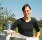 Courtney Schumacher with her group's disdrometer, an instrument that measures the drop size distribution of rain (essentially a very expensive microphone). (Image courtesy of Texas A&M University)