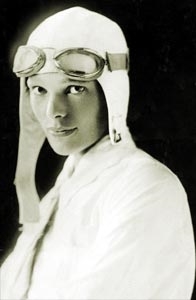 Amelia in a white aviator suit and cap in white (http://www.ameliaearhart.com/about/historicalphotos.html)