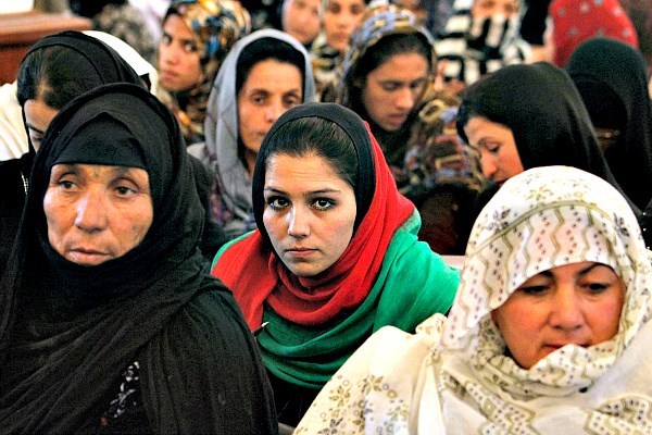 Women listen to a speech by Afghanistan's President Hamid Karzai in Kabul in May 2013. The Afghan Women’s Writing Project is helping women express their thoughts and opinions through poetry. But the identity of women poets must be carefully guarded for their own safety.  <P>Omar Sobhani/Reuters/File