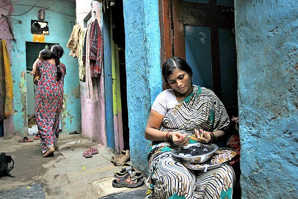 Shobha Vakade, who took a loan of rupees 18,000 ($400) from a microfinance company to start her own business, strings beads into necklaces outside her house in a slum in Mumbai, India. Microloan groups are expanding to include other services to clients, including savings accounts and health and education services.  <P>Danish Siddiqui/Reuters/File