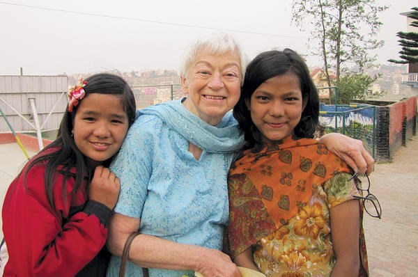 Olga Murray poses with two of the many girls she has helped through the Nepal Youth Foundation, which she founded in 1990.