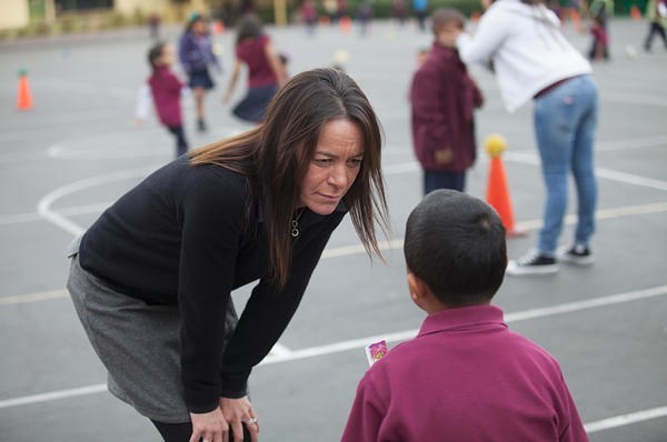 Jennifer Epps, principal of Synergy Charter Academy in Los Angeles, talks to a student about his homework on the playground.  <P>Stephanie Diani/Special to The Christian Science Monitor