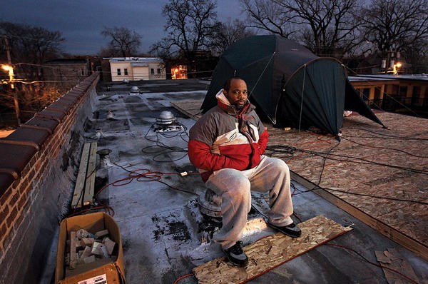 Pastor Corey Brooks sits on the roof of an abandoned motel where he camped out across the street from his New Beginnings Church in Chicago. <P>Brian Cassella/Chicago Tribune/Getty Images