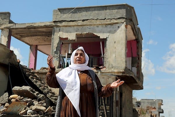 Photo by Sertac Kayar/Reuters.  A woman stands in front of her house damaged during clashes between Turkish security forces and Kurdish militants in the southeastern town of Idil, Turkey, March 31. A Turkish news agency run by female journalists is emphasizing the stories of women in the region.