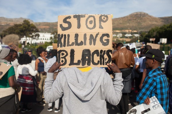 A protester holds a banner stating "Stop killing blacks" during a black solidarity protest outside the US Consulate in Cape Town, South Africa on July 13, 2016. The protest comes a week after police killed Alton Sterling and Philando Castile in the United States. Photo: Ashraf Hendricks