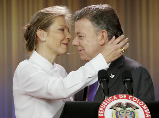 Colombia's President Juan Manuel Santos is embraced by his wife Maria Clemencia Rodriguez after speaking to journalists at the presidential palace in Bogota, Colombia, Friday, Oct. 7, 2016. Santos won the Nobel Peace Prize Friday, just days after voters narrowly rejected a peace deal he signed with rebels of the Revolutionary Armed Forces of Colombia, FARC. (AP Photo/Fernando Vergara)