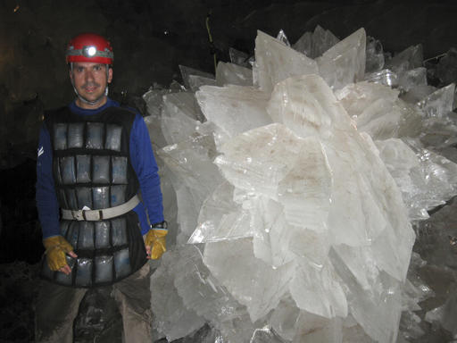 In this image provided by Mike Spilde, Mario Corsalini stands near to a gypsum rosette crystal. In a Mexican cave system so beautiful and hot that it is called both Fairyland and hell, scientists have discovered life trapped in crystals that could be 50,000 years old. The bizarre and ancient microbes were found dormant in caves in Naica, Mexico, and were able to exist by living on minerals such as iron and manganese, said Penelope Boston, head of NASA's Astrobiology Institute. (Mike Spilde via AP)