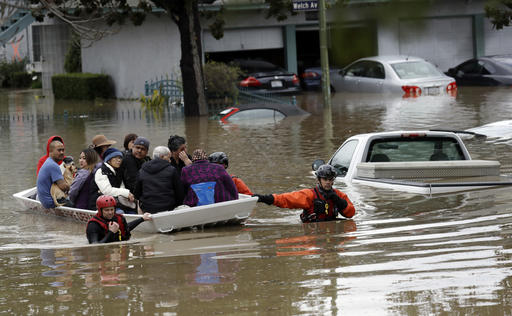 Rescue crews take out residents from a flooded neighborhood Tuesday, Feb. 21, 2017, in San Jose, Calif. Rescuers chest-deep in water steered boats carrying dozens of people, some with babies and pets, from a San Jose neighborhood inundated by water from an overflowing creek Tuesday. (AP Photo/Marcio Jose Sanchez)