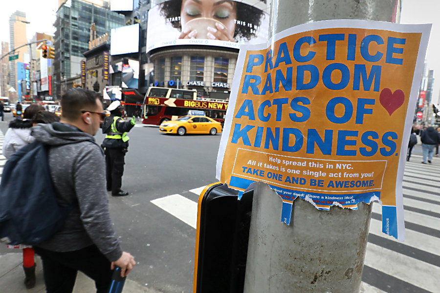 People walk past a “Practice Random Acts of Kindness” sign in New York’s Times Square, Feb. 19. (Carlo Allegri/Reuters)