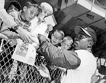 Hank Aaron signing autographs before a game. (http://www.sportingnews.com/archives/aaron/photo1.html)