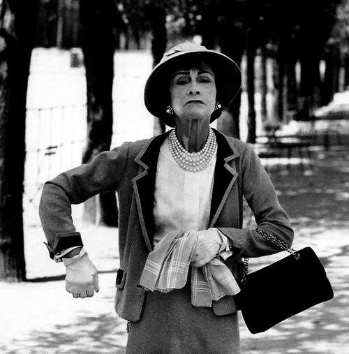 Coco with her classic designs. (http://frillr.com/files/images/Gabrielle%20Coco%20Chanel.jpg)