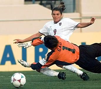 Hamm scoring and goalie diving for the ball (www.7butterflies.com/.../mia_hamm_image2.jpg)