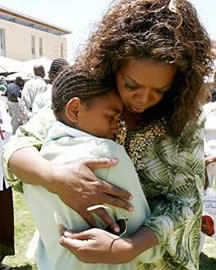 Oprah hugging a homeless boy. (http://cm1.theinsider.com/media/0/41/75/building-dream-oprah2.0.0.0x0.264x330.jpeg)