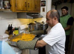 Muñoz preparing hot meals to go hand out (Huffington Post)