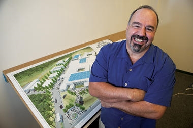 Jim Ansara stands in his Beverly, Mass., office with an architect’s rendering of the hospital he is building with nonprofit Partners in Health in Port-au-Prince, Haiti. The facility is scheduled to open in November. Mr. Ansara made enough as the owner of a construction business to retire in his 40s.