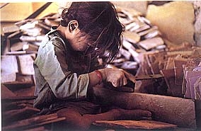 A kid working in a Chinese sweatshop. (http://www.stylesalad.com/2011/03/youre-being-fooled/)
