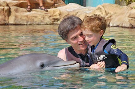 Pausch with his son, Dylan, playing with dolphins (http://cheerfulmonk.com/wp-content/uploads/2008/07/randyanddylanwithdolphon-438.jpg)