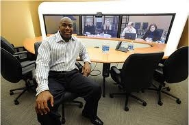 Magic sitting at his work during a video confrenc (http://www.telepresenceoptions.com/2008/11/magic_johnson_discusses_video/)