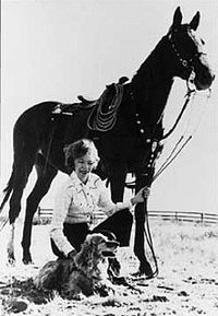 Annie on her farm with her horse, and her dog