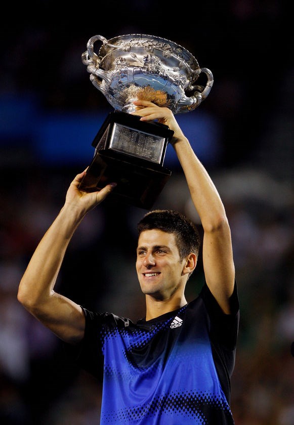 Novak holding a trophie ( ())