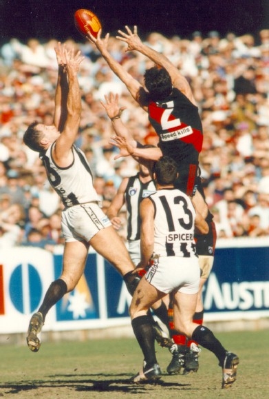 An essendon player going for the mark