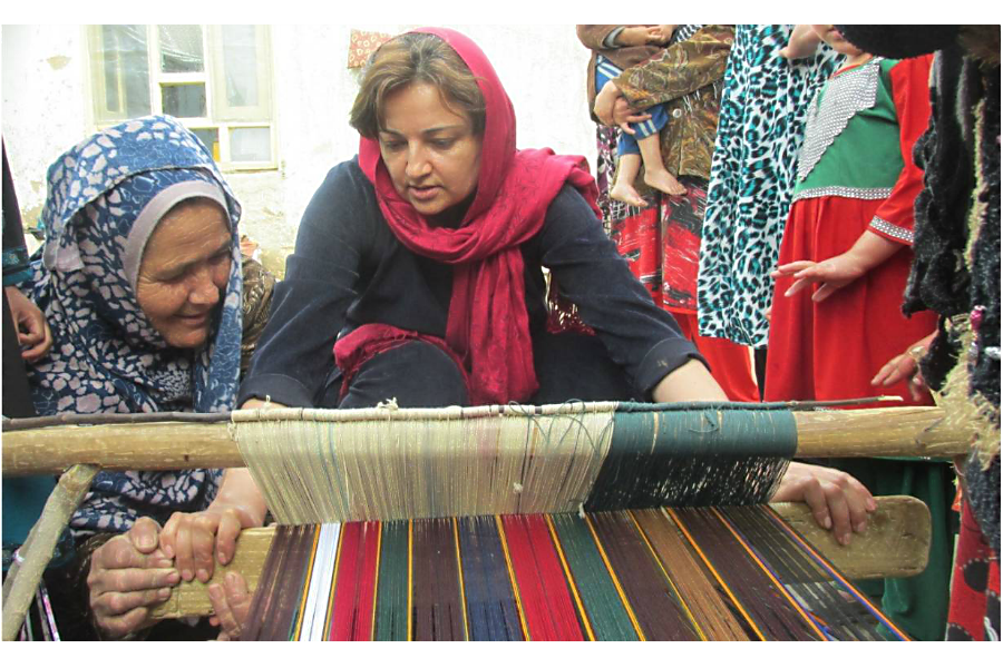Women show Seema Ghani how to make shawls in Qizel Kent village, Afganistan, in 2015. (Courtesy of Hand in Hand Afghanistan)