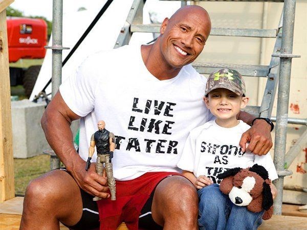The Rock is with a boy who is battling cancer (https://www.pinterest.com/j3n87/make-a-wish-come-t ())