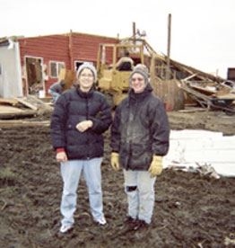 Barbara Ries is on the left, standing in front of the foundation wall one week after the storm.