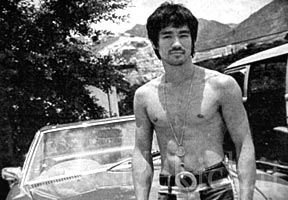 Bruce Lee standing beside his Mercedes in 1972