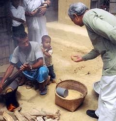 Muhammad Yunus helping a man and little boy.