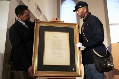 African American Civil War Museum founder and Executive Director Dr. Frank Smith Jr. (left) and Kevin Douglass-Green, great-great-grandson of Fredrick Douglass, position an original copy of the Emancipation Proclamation.  (howstuffworks.com)