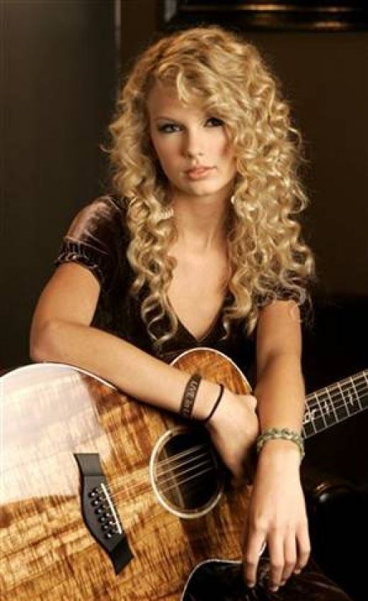 Taylor Swift with one of her many guitars. (hubpages.com)