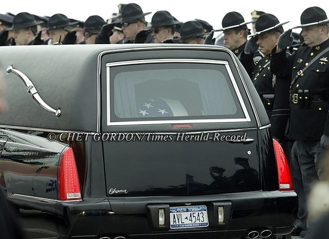 John in his Casket in the back of a Hearse (Google Images)