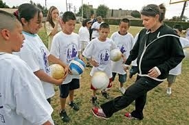 Mia Hamm teaching kids how to kick a soccer ball (miafoundation.org ())