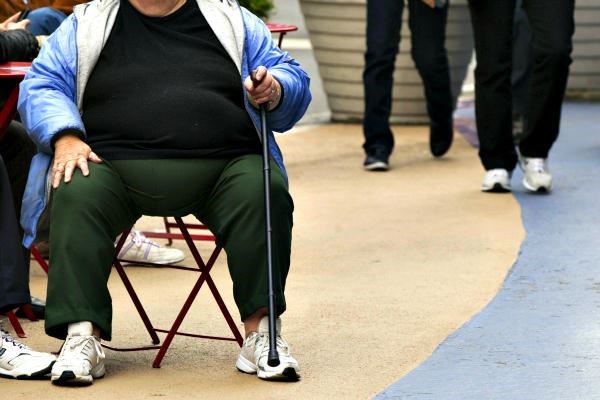 An overweight woman sits on a chair in Times Square in New York. The startup 'Halfsies' aims to cut obesity and increase food aid to the hungry by serving diners half a portion and donating the cost of the rest of the meal to charity. <P>Lucas Jackson/Reuters