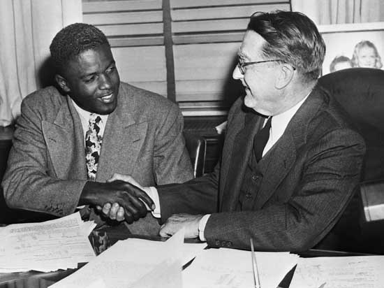 Jackie Robinson signs major league contract (Google Images)