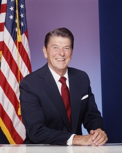 Reagan posing in front of an American Flag. (http://www.whenguide.com/when-did-ronald-reagan-become-president.html)