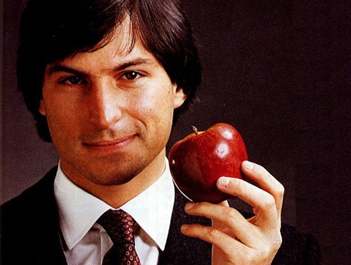 A young Steve Jobs holding an apple (http://4.mshcdn.com/wp-content/gallery/steve-jobs-life-amp-times/jobs_1980s.jpg ())