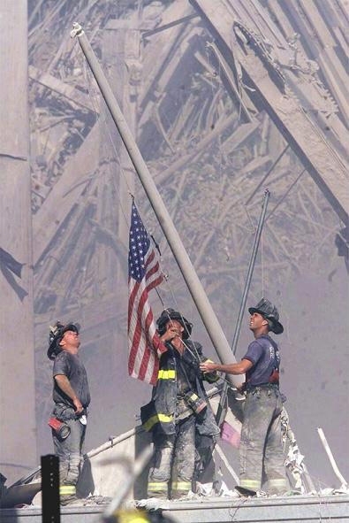 Three FDNY Firefighters raise the American flag. (arlingtoncemetary.net ())